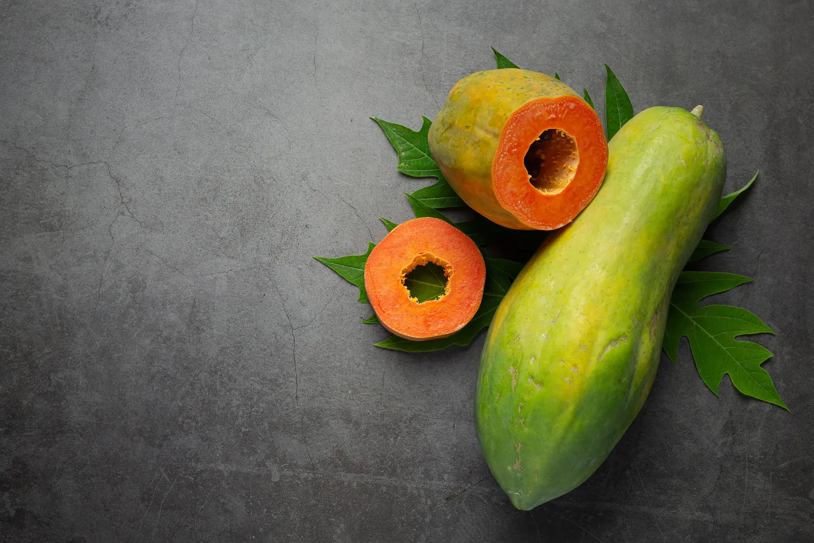 Papaya cut in half, orange flesh and black seeds
