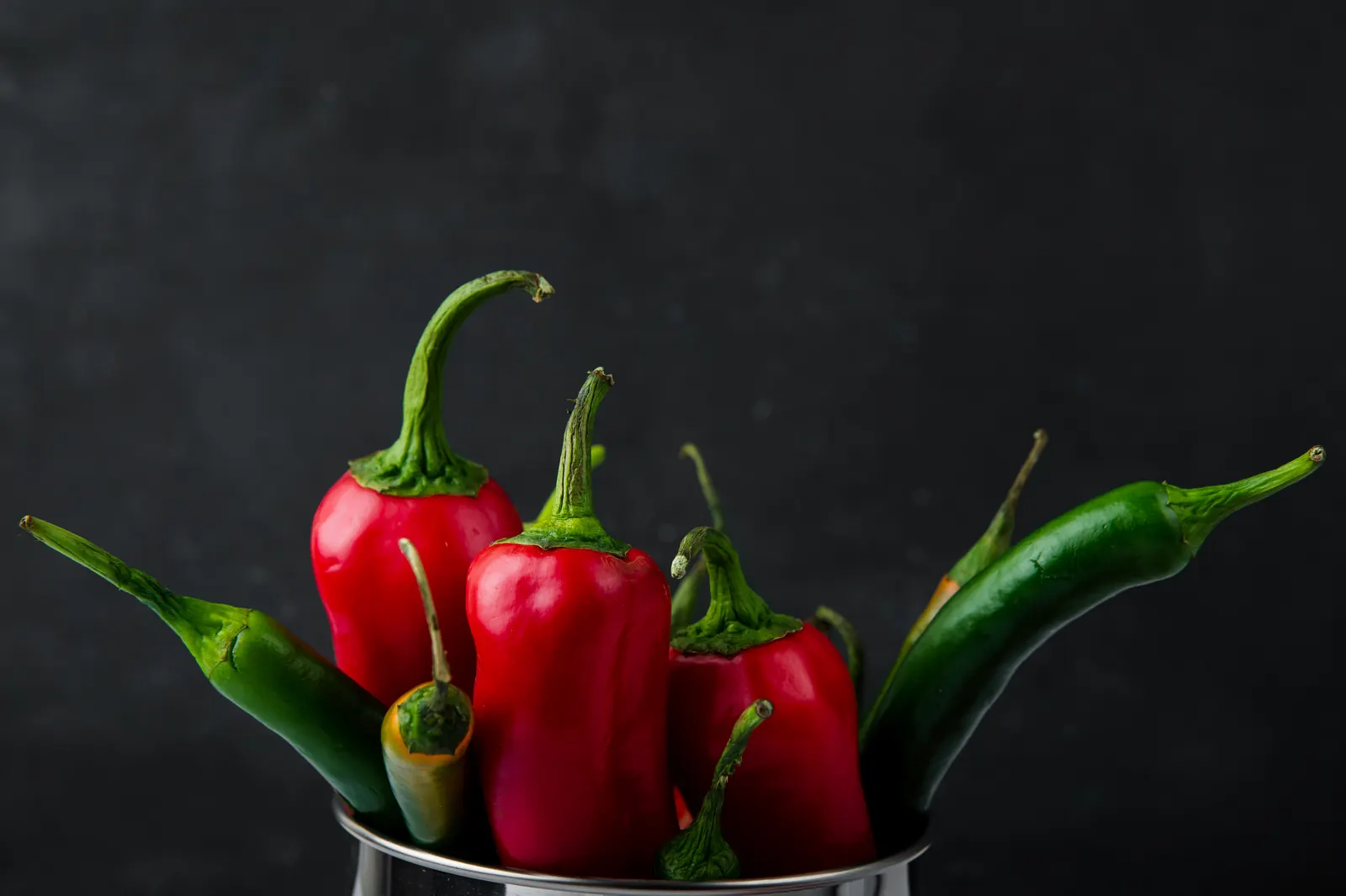 Fresh red chili peppers on a dark background